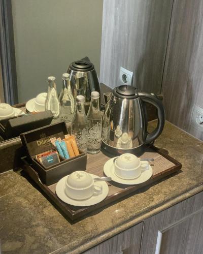 a tray with a tea kettle and plates on a counter at Melia Purosani Yogyakarta in Yogyakarta