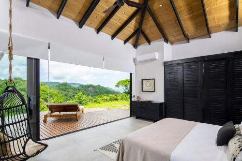 a bedroom with a swinging bed and a patio at Villa Ayla - Santa Teresa Minutes From The Beach in Carmen