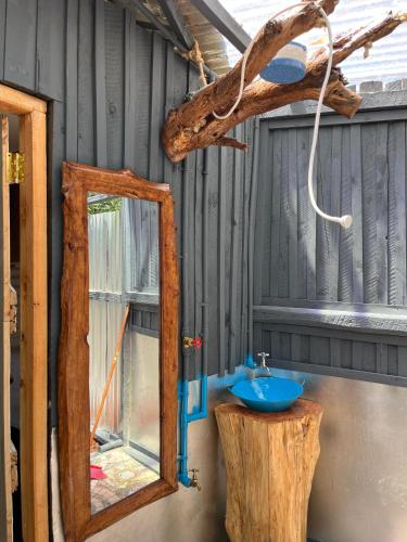 a bathroom with a mirror and a blue sink at Citronella Mountain Cottage Nanyuki in Nanyuki