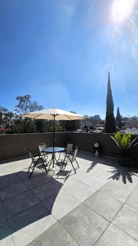 a table and chairs with an umbrella on a patio at C46-R02 STUDIO at ITESM CEM Families Tourists & Travelers Choice Foreign Students Companies Executives WELCOME!!! 10min Izcalli-15min Esmeralda-20min Sátelite-25min AIFA in Mexico City