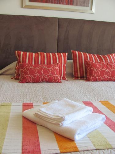 a bed with a towel on it with pillows at Apartamento en Cetro Real Condominium & Suites in Rosario