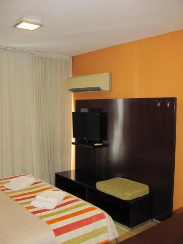 a hotel room with a bed and a tv at Apartamento en Cetro Real Condominium & Suites in Rosario