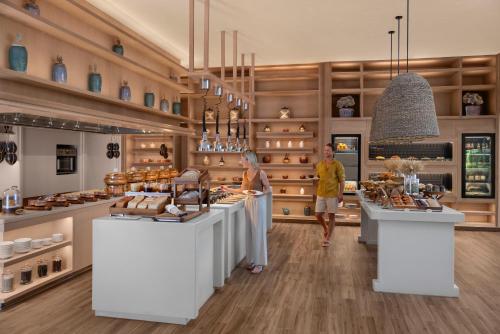 two people are standing in a pastry shop at Waldorf Astoria Maldives Ithaafushi in South Male Atoll