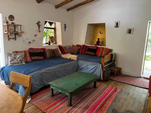 a living room with a couch and a table at Casita Río Floresta Pisac in Pisac