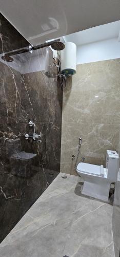 a bathroom with a toilet and a stone wall at Kashi Om Vilas Homestay in Varanasi