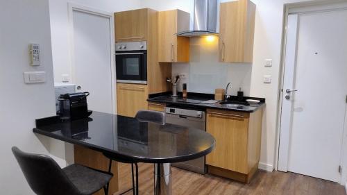 une cuisine avec un comptoir noir dans une pièce dans l'établissement cozy apartment port of Nice, à Nice