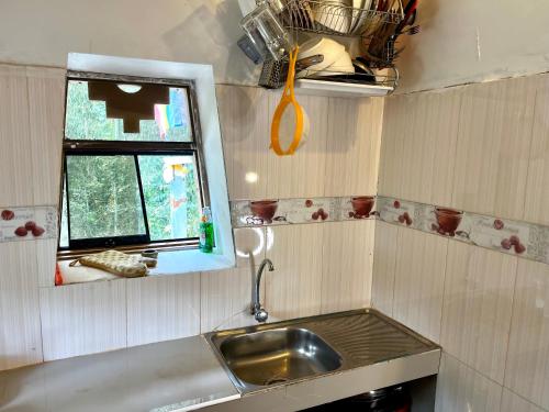 a small kitchen with a sink and a window at Casita Río Floresta Pisac in Pisac