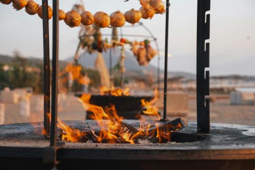 a grill with a bunch of food on fire at W Costa Navarino in Pylos