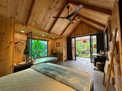 a bedroom with a bed and a ceiling fan at Nomia Garden Retreats - Khu nghỉ dưỡng hồ Trị An in Xóm Ðốt Ðó