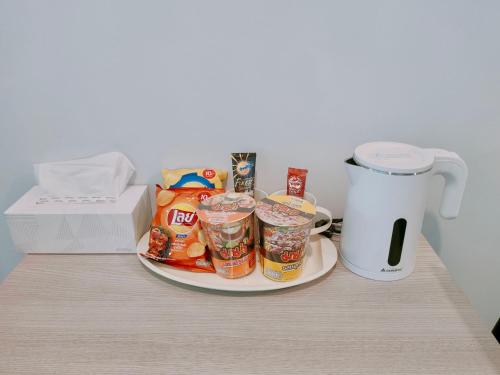 a plate of food on a table next to a blender at The Kith Plus - Wifi Swimming Pool Gym BTS Samrong in Ban Khlong Samrong