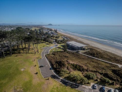 an aerial view of a beach and a road at Unwind Papamoa Beach - Papamoa Holiday Home in Papamoa