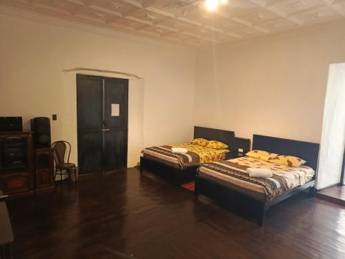 two beds in a room with wooden floors at Suite Cardinal - El Renacimiento Suites in Cuenca
