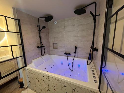 a bath tub with two lights in a bathroom at COCON Mayennais - Loft Balnéo Laval - Loveroom in Laval