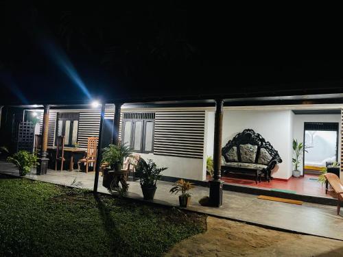 a house is lit up at night with a couch at Solo's Shelter Hostel Udawalawa in Udawalawe