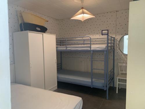 une chambre avec deux lits superposés et une lampe dans l'établissement Coquet Chalet à 50m de la Plage - 6 Pers, Terrasse, TV, Lave-vaisselle - FR-1-796-42, à Gruissan