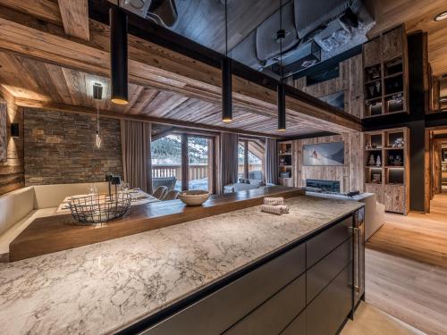 Il comprend une cuisine dotée de plafonds en bois et d'un grand comptoir. dans l'établissement Location à Méribel : charmant appartement en location saisonnière - FR-1-613-122, à Les Allues