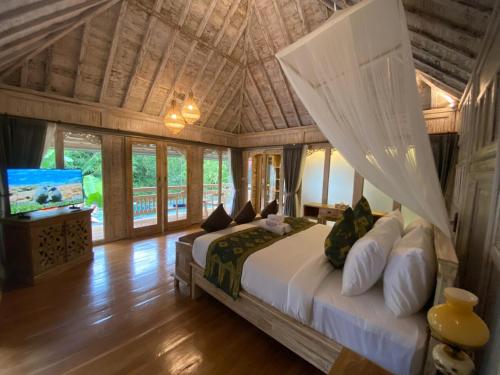 ウブドにあるAbimartha Villa Ubudの天井の大型ベッド付きのベッドルーム1室