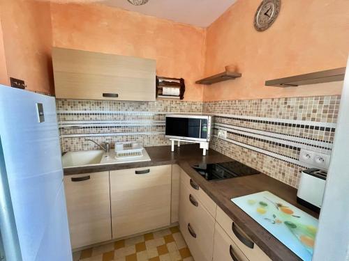 une petite cuisine avec un évier et un réfrigérateur dans l'établissement Studio central avec parking, proche plage - FR-1-716-78, à La Grande Motte