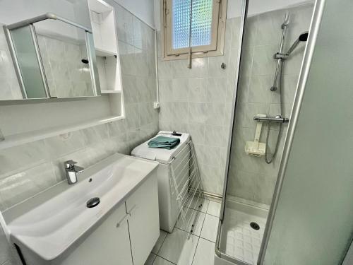 une salle de bain blanche avec un lavabo et une douche dans l'établissement Studio central avec parking, proche plage - FR-1-716-78, à La Grande Motte