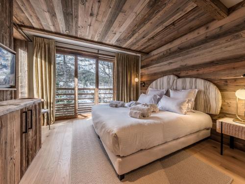 - une chambre avec un grand lit et un plafond en bois dans l'établissement Séjour de luxe : sauna, hammam, home cinéma, concierge 5* - FR-1-613-128, à Les Allues