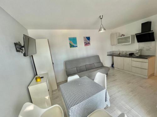 Il comprend un petit salon avec une table et une cuisine. dans l'établissement Studio confortable pour 4 pers avec parking à 10 min de la plage - FR-1-716-77, à La Grande Motte