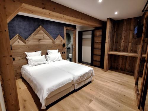 une chambre avec un grand lit blanc et des murs en bois dans l'établissement Appartement 7 personnes aux Gets avec Wi-Fi - FR-1-671-285, aux Gets