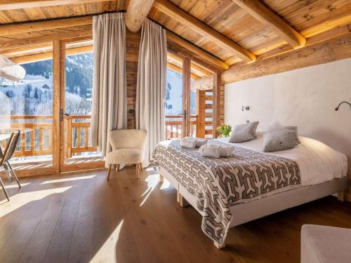 une chambre avec un lit et une grande fenêtre dans l'établissement Chalet 5*****, 15 pers., proche piste, piscine, sauna - FR-1-304-300, à La Clusaz