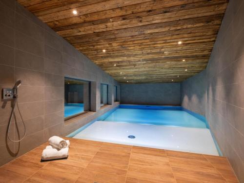La salle de bains est pourvue d'une baignoire et d'un plafond en bois. dans l'établissement Chalet 5*****, 15 pers., proche piste, piscine, sauna - FR-1-304-300, à La Clusaz