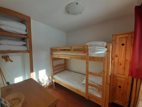 une chambre avec deux lits superposés et une table dans l'établissement Studio cabine 4 pers à Valfréjus, proche télécabine - FR-1-561-138, à Modane