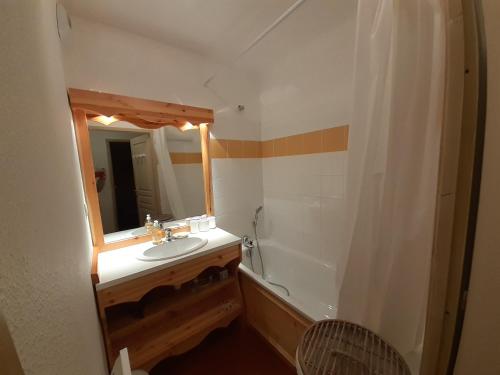 une salle de bain avec un lavabo, une baignoire et un miroir dans l'établissement Studio cabine 4 pers à Valfréjus, proche télécabine - FR-1-561-138, à Modane