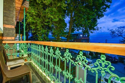 a balcony with a green fence and a bench at D's Casa - A Unique Spanish Boutique House in McLeod Ganj