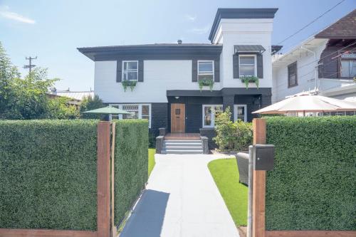 a house with a hedge fence and a walkway at Burlington Hostel in Los Angeles
