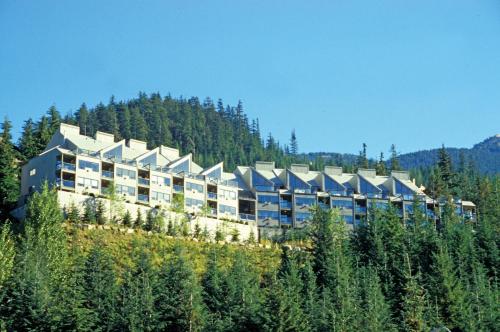 a large building on top of a hill with trees at Worldmark Whistler Sundance in Whistler