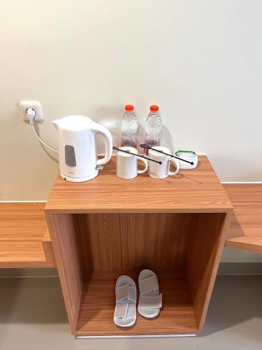 a wooden shelf with cups and bottles and shoes on it at Lakeside TELL Cikarang in Ceper 2