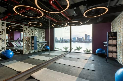 a yoga room with a view of the water at Wink Icon Hotel Danang Riverside - 24hrs Stay & Rooftop Pool Bar in Da Nang