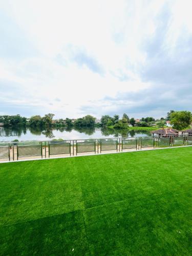 a grassy field next to a body of water at Lakeside TELL Cikarang in Ceper 2