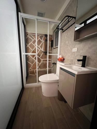 a bathroom with a shower and a toilet and a sink at 心如所院民宿 in Hsia-shih