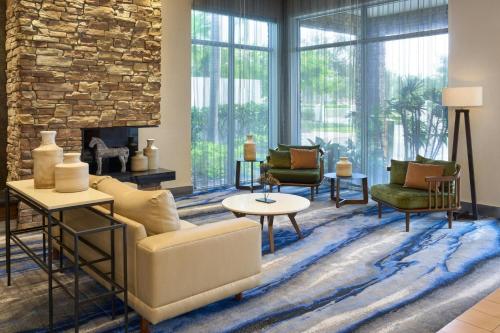 a living room with a couch and chairs and a fireplace at Fairfield Inn & Suites by Marriott Delray Beach I-95 in Delray Beach