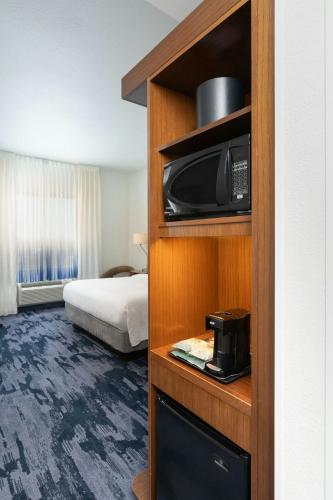 a hotel room with a bed and a microwave at Fairfield Inn & Suites by Marriott Delray Beach I-95 in Delray Beach