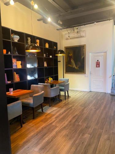 a dining room with two tables and chairs and a wall with shelves at Central Hostel in Sheki