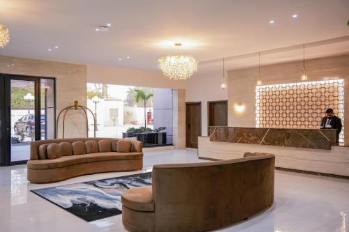 a lobby with two brown leather chairs and a counter at Lahore Grande Boutique Hotel in Lahore