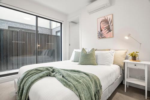 a bedroom with a bed and a window at Paradise Getaway 3BR Apt in Clayton with Free Parking in Clayton North