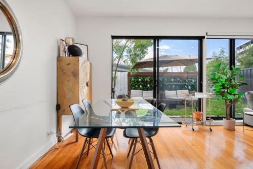 a dining room with a glass table and chairs at Paradise Getaway 3BR Apt in Clayton with Free Parking in Clayton North