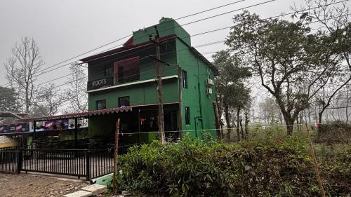 a green house with a train in front of it at ROOTS by MOUNT OLIVE in Siliguri