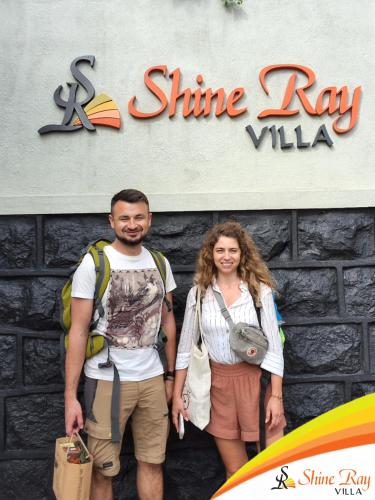 a man and a woman standing in front of a sign at Shine Ray VILLA in Galle