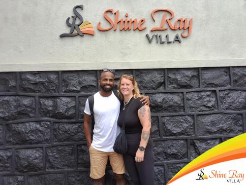 a man and a woman standing in front of a stone wall at Shine Ray VILLA in Galle