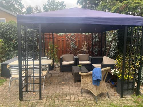 a blue canopy over a patio with chairs and a table at Weltevree in Tegelen