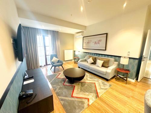 a living room with a couch and a table at Somerset City Centre Atyrau in Atyraū