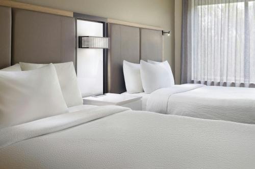 two beds in a hotel room with white pillows at SpringHill Suites Raleigh-Durham Airport/Research Triangle Park in Durham