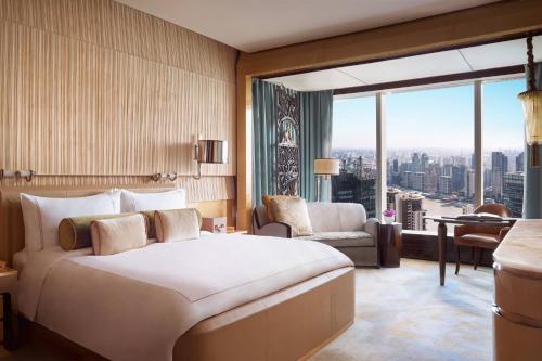 a hotel room with a bed and a large window at The Ritz-Carlton Shanghai, Pudong in Shanghai
